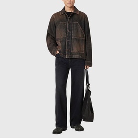 Model wearing All Saints washed brown distressed denim jacket, styled with black wide-leg jeans and carrying a black tote bag.