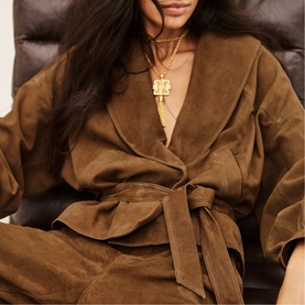 Model wearing Bash Manon Belted Suede Jacket in brown with large cowl collar and detachable belt, styled with gold layered necklaces.
