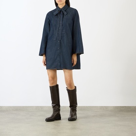 Model wearing FRAME DENIM Rinse denim shirt dress with spread collar, styled with dark brown knee-high boots.