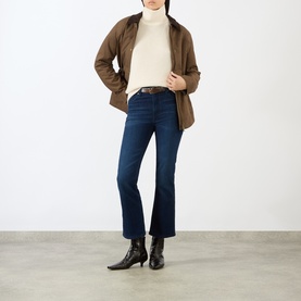 Model wearing FRAME DENIM ecru wool turtleneck knit, styled with brown jacket, dark indigo flared jeans and black ankle boots