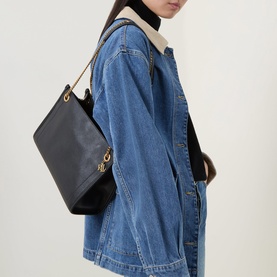 Model carrying Lauren Grained Leather Chain Shoulder Bag in black with gold-toned double chain straps, styled with a denim jacket