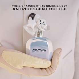 Marc Jacobs Just Perfect Eau de Parfum in iridescent blue bottle with white star and daisy charms, held in a gloved hand