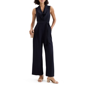Model wearing Phase Eight blue sleeveless wide-leg jumpsuit with cowl neck and self-tie belt, styled with nude heeled mules and clutch bag