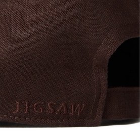 Jigsaw brown cap, close-up of back panel showing embossed Jigsaw logo and adjustable opening.