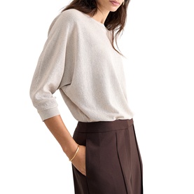 Model wearing Phase Eight gold fine knit batwing jumper with three-quarter sleeves, styled with dark brown wide-leg trousers