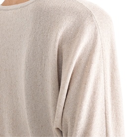 Model wearing Phase Eight gold fine knit jumper, close-up of shoulder and sleeve detail showing subtle shimmer texture