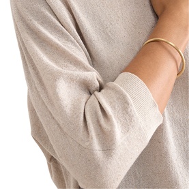 Model wearing Phase Eight gold fine knit top, cropped sleeve detail, styled with a gold-tone bangle bracelet