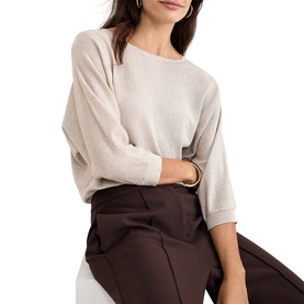 Model wearing Phase Eight gold knit sweater with batwing sleeves, styled with dark brown wide-leg trousers