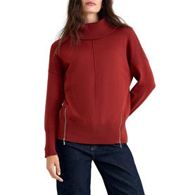 Model wearing Phase Eight orange roll neck knit jumper with zip hem detail, styled with dark navy jeans.