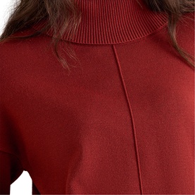 Model wearing Phase Eight orange fine knit turtleneck jumper, with ribbed collar and centre seam detail, close-up view.