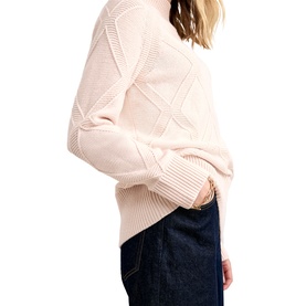 Model wearing Phase Eight pink cable-knit jumper with ribbed cuffs and hem, styled with dark denim jeans, side angle view
