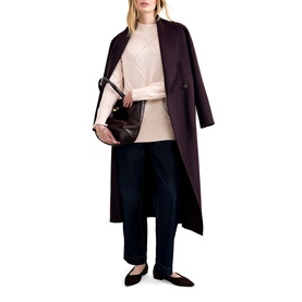 Model wearing Phase Eight pink cable-knit jumper, styled with dark burgundy longline coat, navy wide-leg trousers, and black ballet flats