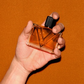 Valentino Vendetta Uomo Eau de Parfum For Men, amber-tinted angular glass bottle with black ridged cap, held in hand