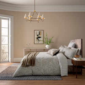 Grey jacquard duvet set styled on a double bed with coordinating cushions, throw, and sideboard in a neutral-toned bedroom.