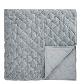 Dusty blue quilted bedspread with diamond stitch pattern, corner folded back to reveal pale grey reverse side