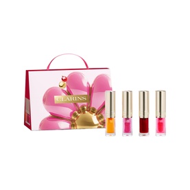 Clarins Lip Comfort Oil Mini Collection Gift Set with four mini lip oil bottles in orange, pink, berry and red shades beside pink floral gift box