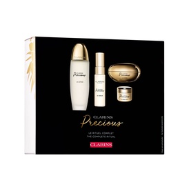 Clarins Precious Complete Ritual Gift Set with lotion, serum, eye cream and moisturiser in gold and white packaging on black box