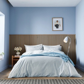 Helena Springfield Navy Duvet Set styled on a double bed with matching pillowcases, shown in a minimal blue bedroom setting.