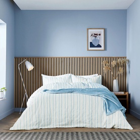 Helena Springfield Navy Duvet Set styled on a double bed with white and blue stripe design, in a light blue Scandinavian-style bedroom