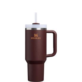 Stanley tumbler in coffee brown with white lid, reusable straw, and handle. Insulated travel cup with engraved bear logo.
