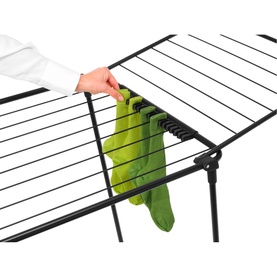 Brabantia Matt Black drying rack with folding arms, shown with green socks being hung using integrated clips