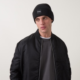 Model with Columbia City Trek&trade; Heavyweight Logo Beanie Hat in black, styled with black quilted bomber jacket and grey tee