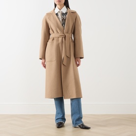 Model wearing Max Mara camel wool belted longline coat, styled with blue wide-leg jeans and printed shirt