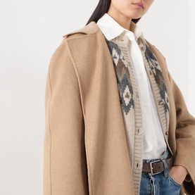 Model wearing Max Mara Main camel wool coat, styled with a patterned knit cardigan, white shirt and blue jeans