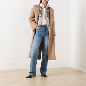 Model wearing Max Mara Main camel wool coat, styled with embroidered white shirt, blue wide-leg jeans and black heeled mules.