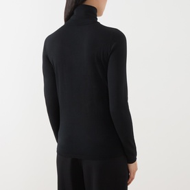Model wearing Max Mara Main black wool turtleneck top, rear view, with black wide-leg trousers