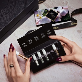 Kilian Paris Heroes Mini Discovery Set 5 x 1.5ml, black gift box with five fragrance vials held in hands with dark red nails