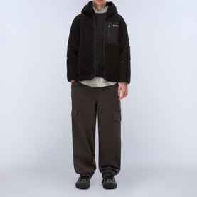 Model wearing Napapijri Black Beauty sherpa jacket, styled with dark cargo trousers and chunky trainers