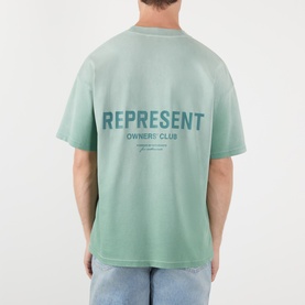 Model wearing Represent Owners Club T-Shirt in Washed Aloe, back view showing tonal logo print, relaxed fit, 100% cotton.