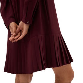 Model wearing Hobbs fig purple dress with long sleeves and pleated drop-waist hem, close-up detail view