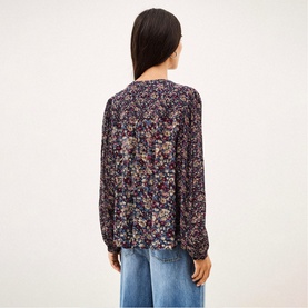 Model wearing Bash blue floral long-sleeve blouse, back view, styled with light wash wide-leg jeans