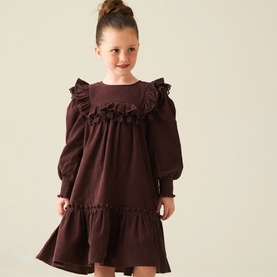 Model wearing Angel & Rocket Chocolate cotton dress with frill yoke neckline, long puff sleeves and tiered hem