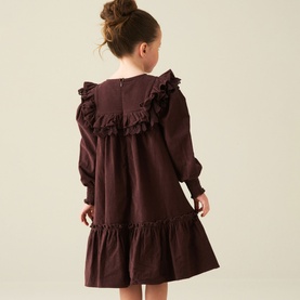 Model wearing Angel & Rocket Chocolate cotton dress with frill collar and tiered hem, back view