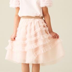 Model wearing Angel & Rocket blush tiered ruffle tulle skirt, styled with a white short-sleeve top