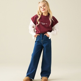 Model wearing Angel & Rocket Denim Blue wide-leg trousers, styled with a burgundy slogan tee and white long-sleeve top.