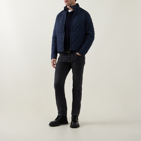 Model wearing Belstaff dark ink quilted casual jacket with black jumper, dark jeans and black leather boots