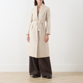 Model wearing Max Mara Studio ecru wool belted wrap coat, styled with wide-leg dark brown trousers and black loafers.