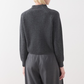 Model wearing Max Mara Studio dark grey wool cashmere ribbed mock-neck sweater, back view, styled with grey wide-leg trousers.