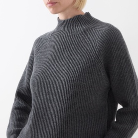 Model wearing Max Mara Studio dark grey ribbed wool-cashmere jumper with mock neck and raglan sleeves, cropped torso view.