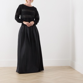 Model wearing Max Mara Studio Divo Metallic-Yarn Striped Sweater in black with boat neck, styled with a black full-length skirt.