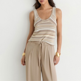Model wearing Reiss beige striped knit tank top with wide-leg trousers and gold cuff bracelets