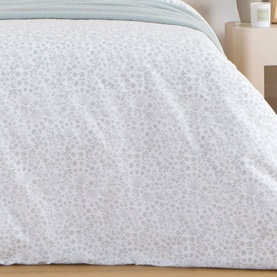 Foxford green floral duvet set styled on a double bed with white pillows, in a bright, minimal bedroom setting