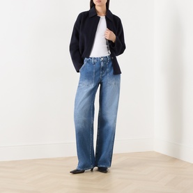 Model wearing LAgence Atlantis wide leg jeans in mid-blue denim, styled with a navy jacket and white tee, black kitten heel mules.