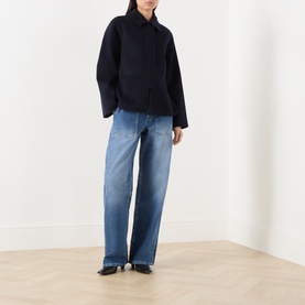 Model wearing LAgence Atlantis Wide Leg jeans in mid-blue denim, styled with a navy wool jacket and black heels.