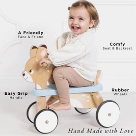 Toddler riding Le Toy Van Petilou wooden deer ride-on toy with blue footrest, rubber wheels, easy-grip handle and padded backrest
