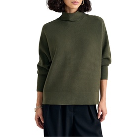 Model wearing Phase Eight dark green funnel-neck knit sweater with dropped shoulders, styled with wide-leg navy trousers